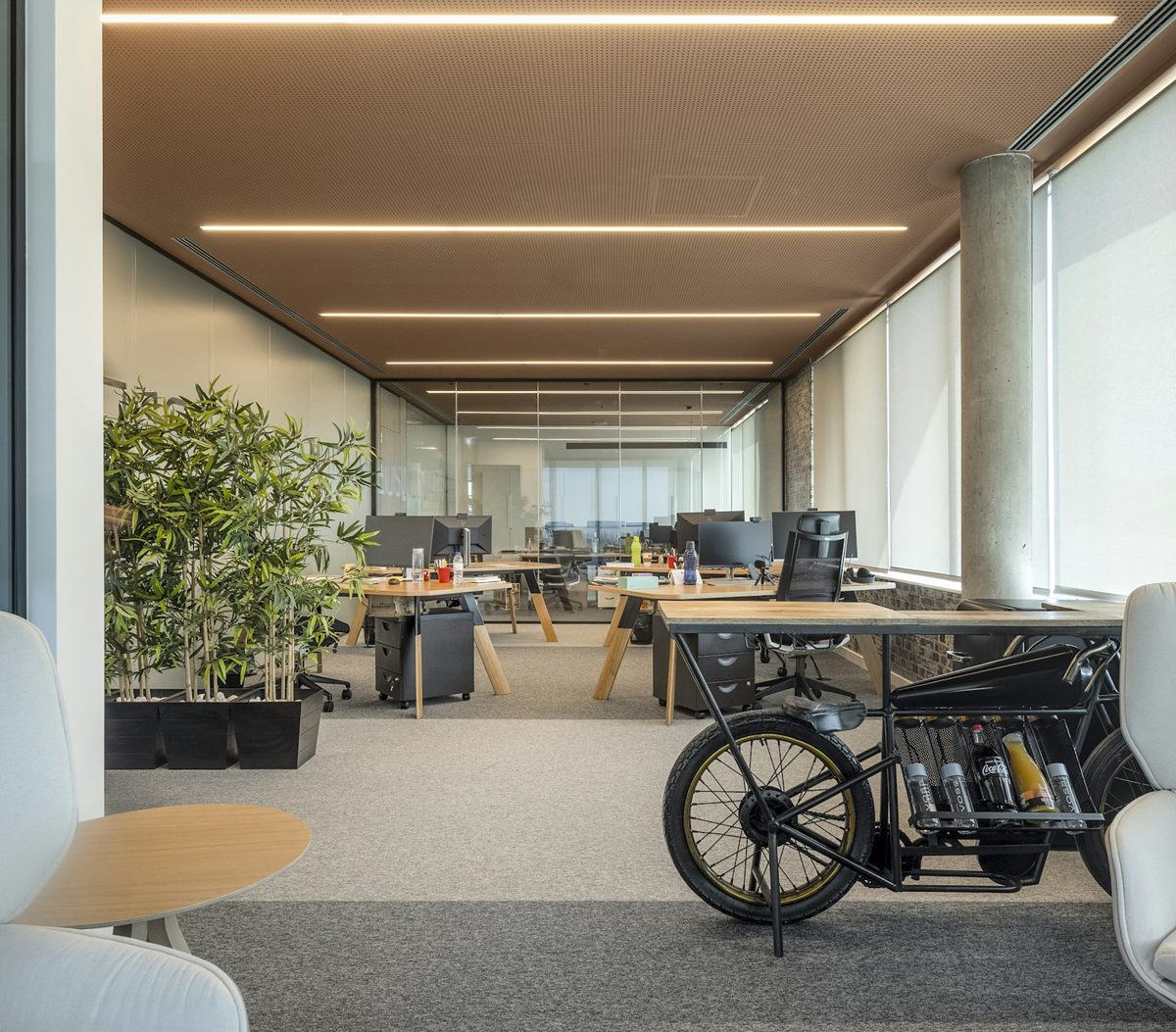 Bureau lumineux avec grandes fenêtres et postes de travail baignés de lumière naturelle